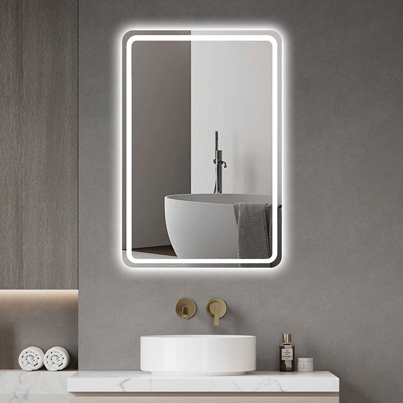 A modern bathroom features the Refurne Smart LED Bathroom Mirror (rectangular, frameless, defogging, adjustable lighting) above a round white sink with a wall-mounted faucet; its glow reflects part of a freestanding tub.