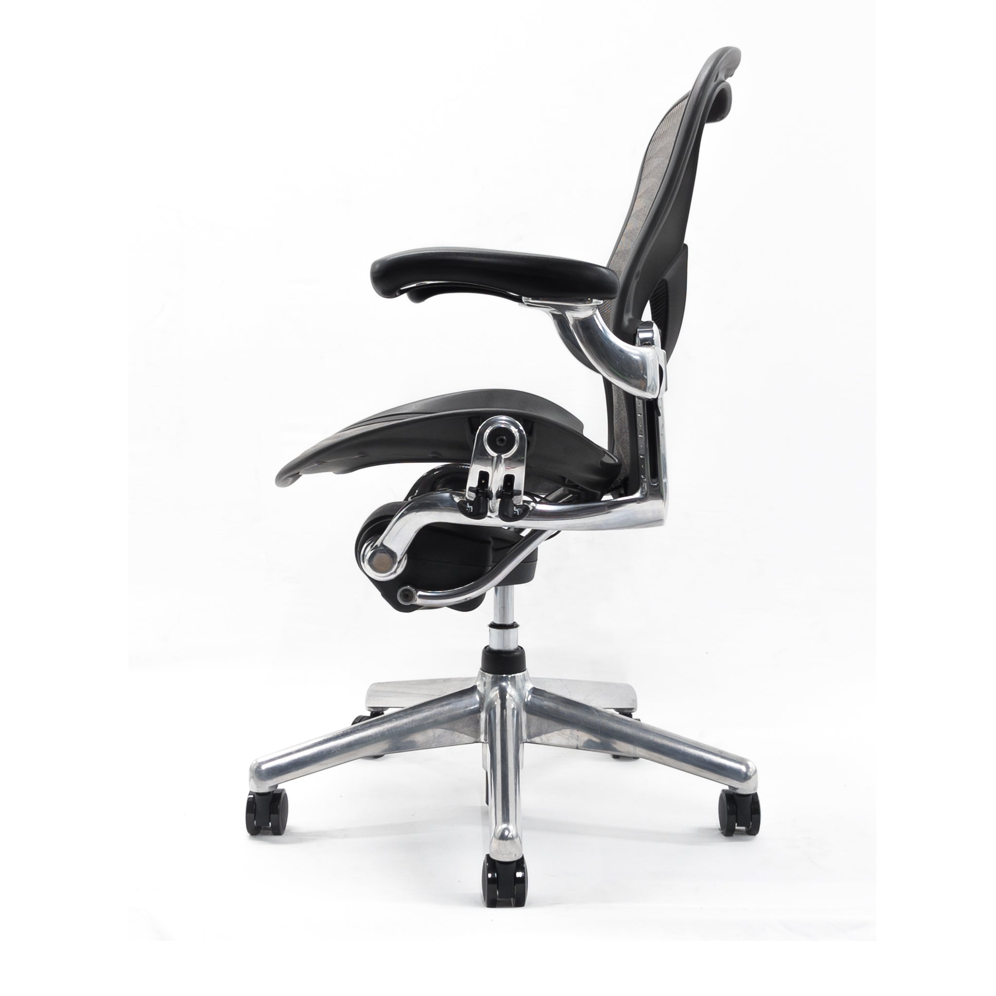 Side view of the Refurne Herman Miller Aeron Posturefit Chrome Office Chair, Size B, FULLY LOADED, with black mesh seat and backrest, metallic armrests and base, adjustable features, and five wheels on a white background.