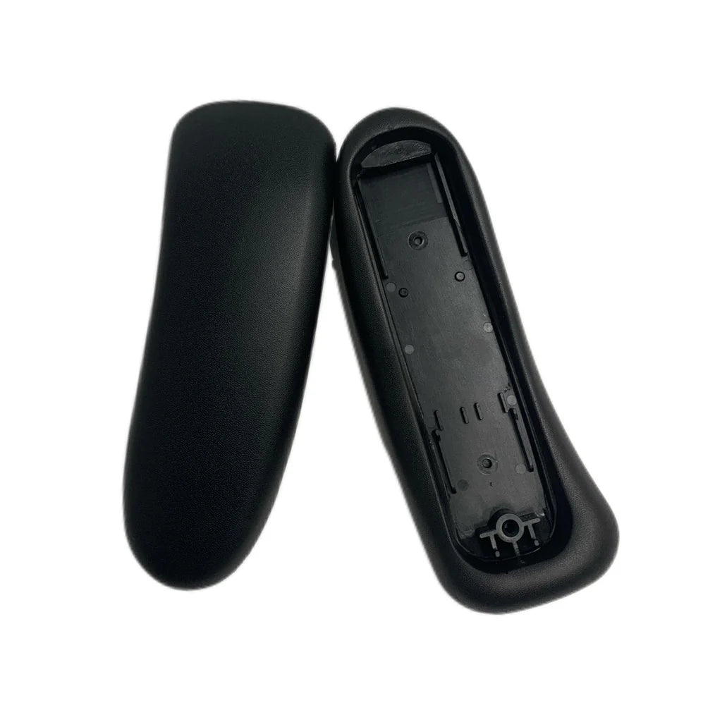 Two black plastic objects are shown: one is a remote control battery cover facedown, the other faceup displaying battery slots—both feature a finish similar to the Refurne Herman Miller Aeron Remastered Replacement Armpads.