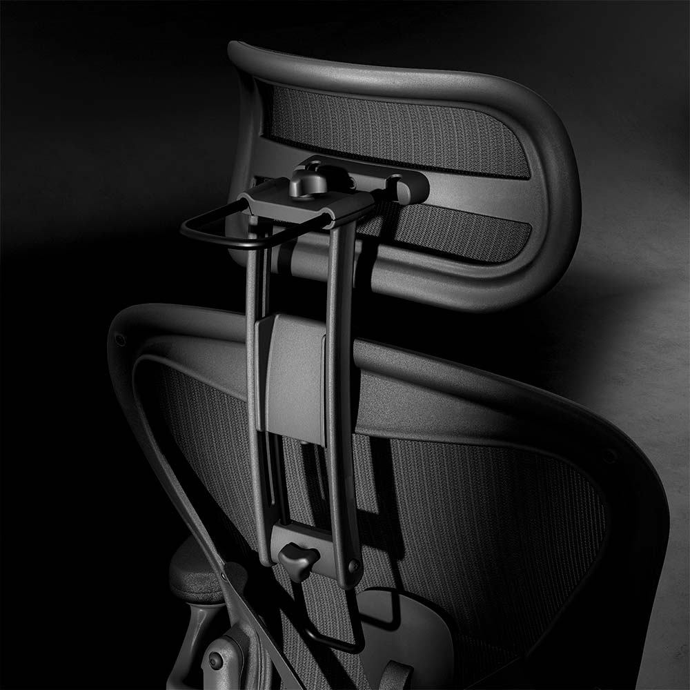Close-up of the Refurne Atlas Headrest for Herman Miller Aeron Remastered Chair in graphite, featuring an adjustable mesh headrest and ergonomic support, set against a dark background.