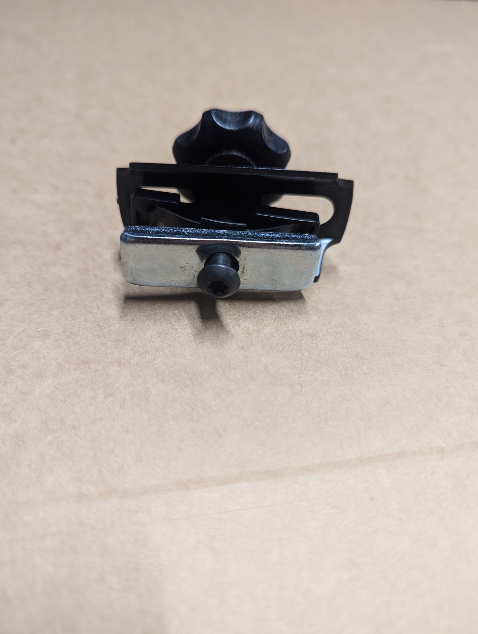 A compact metal and plastic clamp with a black knob by Refurne, designed as an MK1 replacement part for the Roller / Wheel Arm Mechanism on Herman Miller Classic Aeron Chairs.